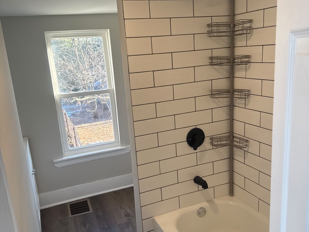 Bathroom with a white subway-tile tub surround and matte-black shower fixtures