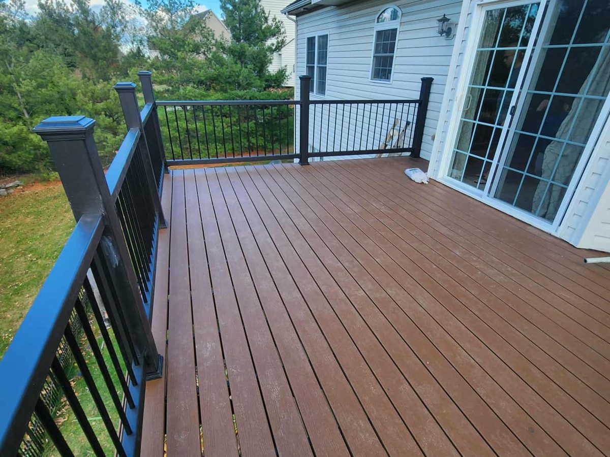 The finished composite deck with black railing and a view over the yard