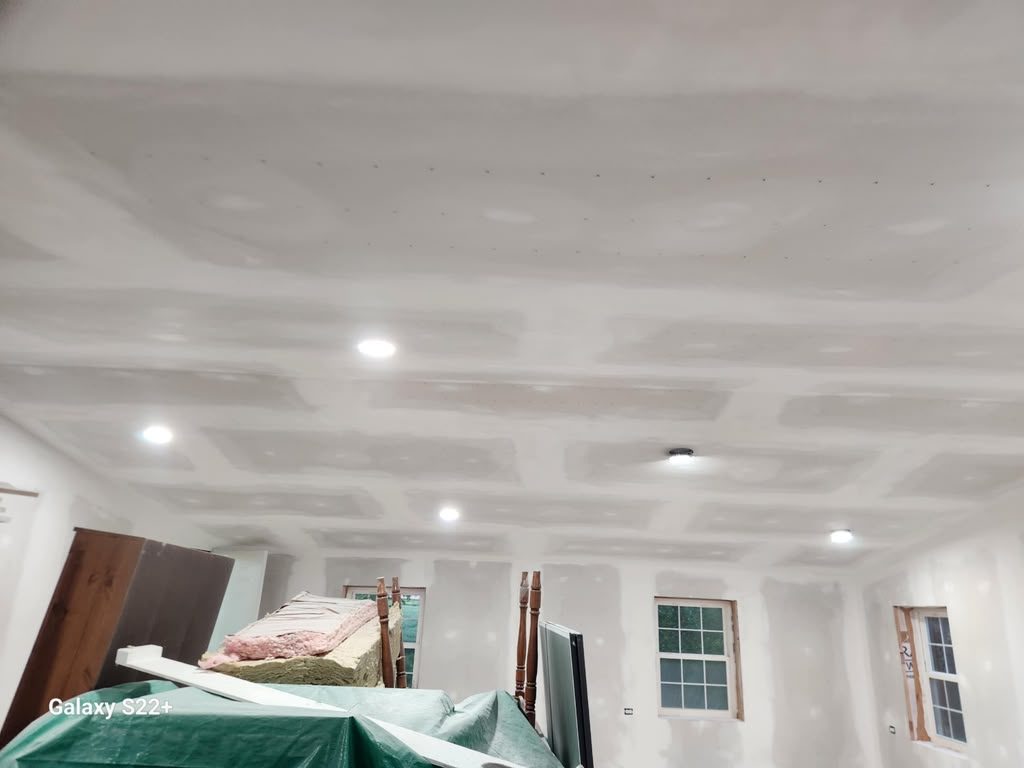 Drywall ceiling hung and taped with recessed light cans, before finish coats