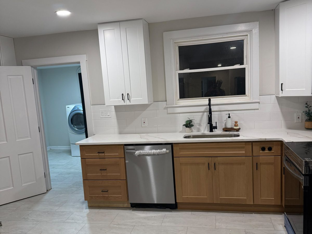 Freshly painted kitchen walls with white shaker cabinets and a tiled backsplash