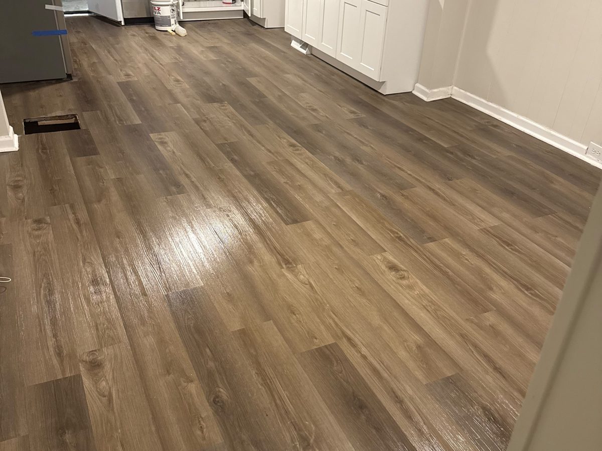New wood-look vinyl plank flooring running through a kitchen and hallway